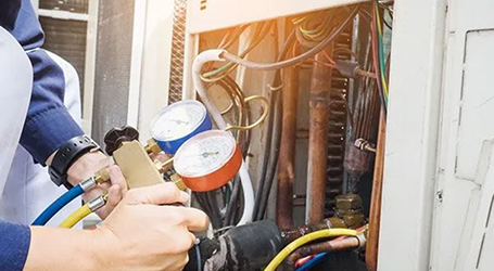 HVAC technician installing a smart thermostat on the wall.